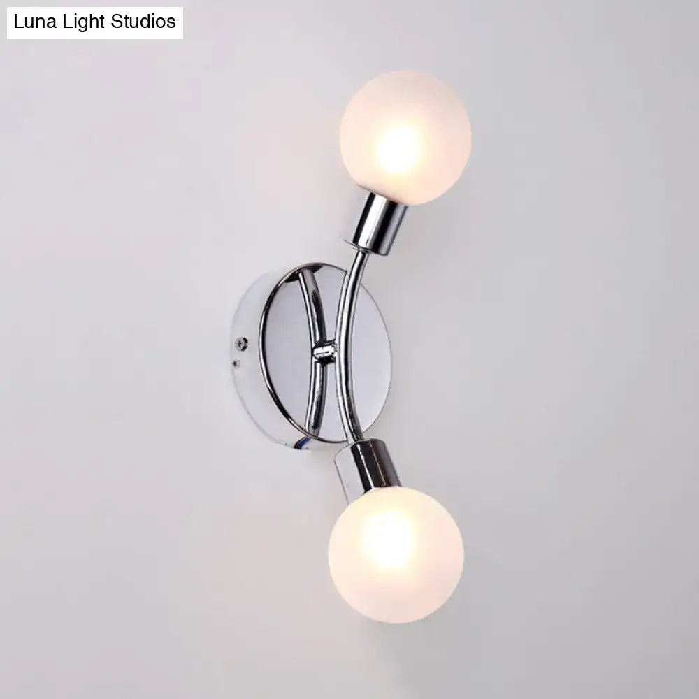 Modern chrome wall lamp with frosted glass fixture and two globe bulbs designed as a bedroom sconce