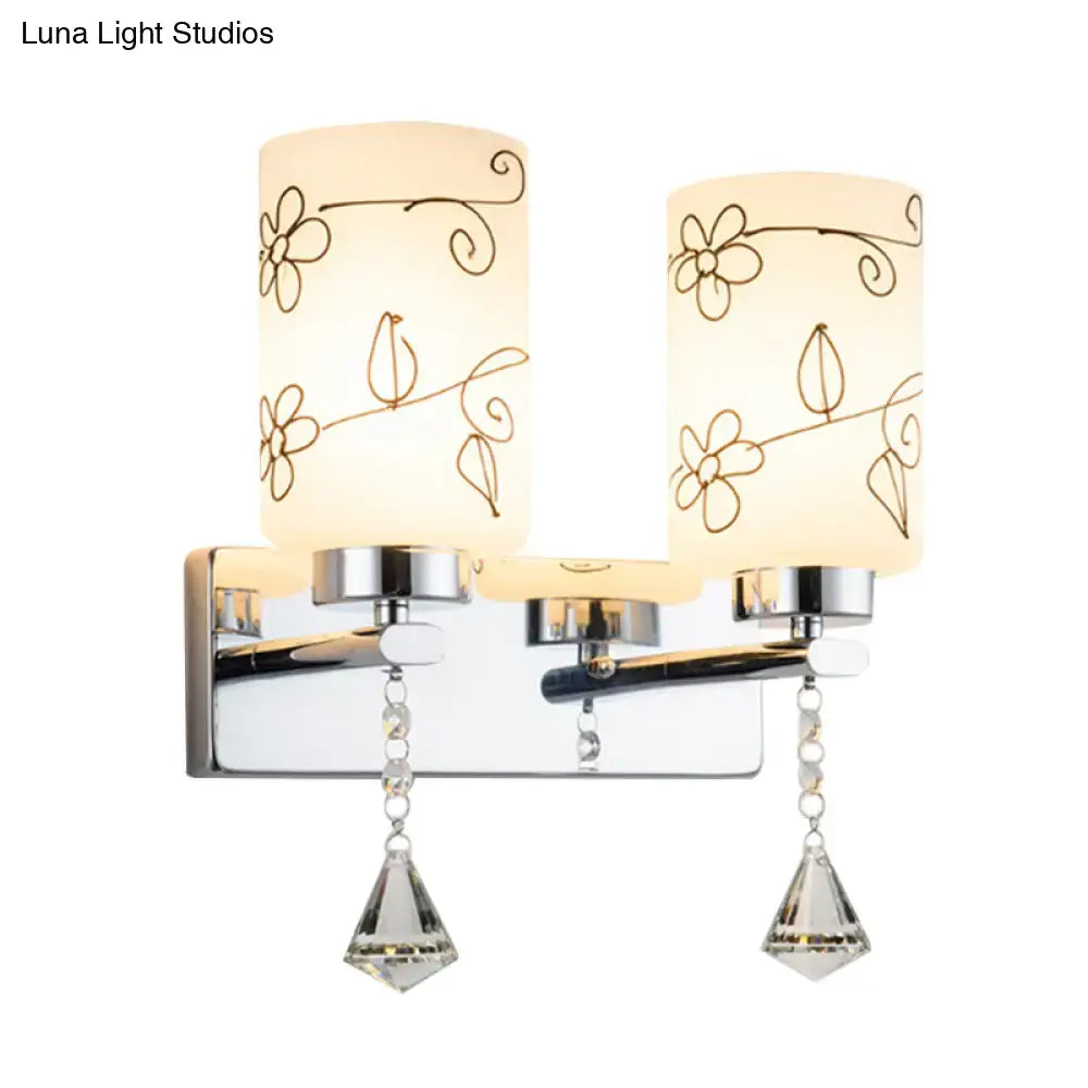 Modern chrome double-light bathroom fixture with white glass cylinder frosted shades and delicate floral etchings