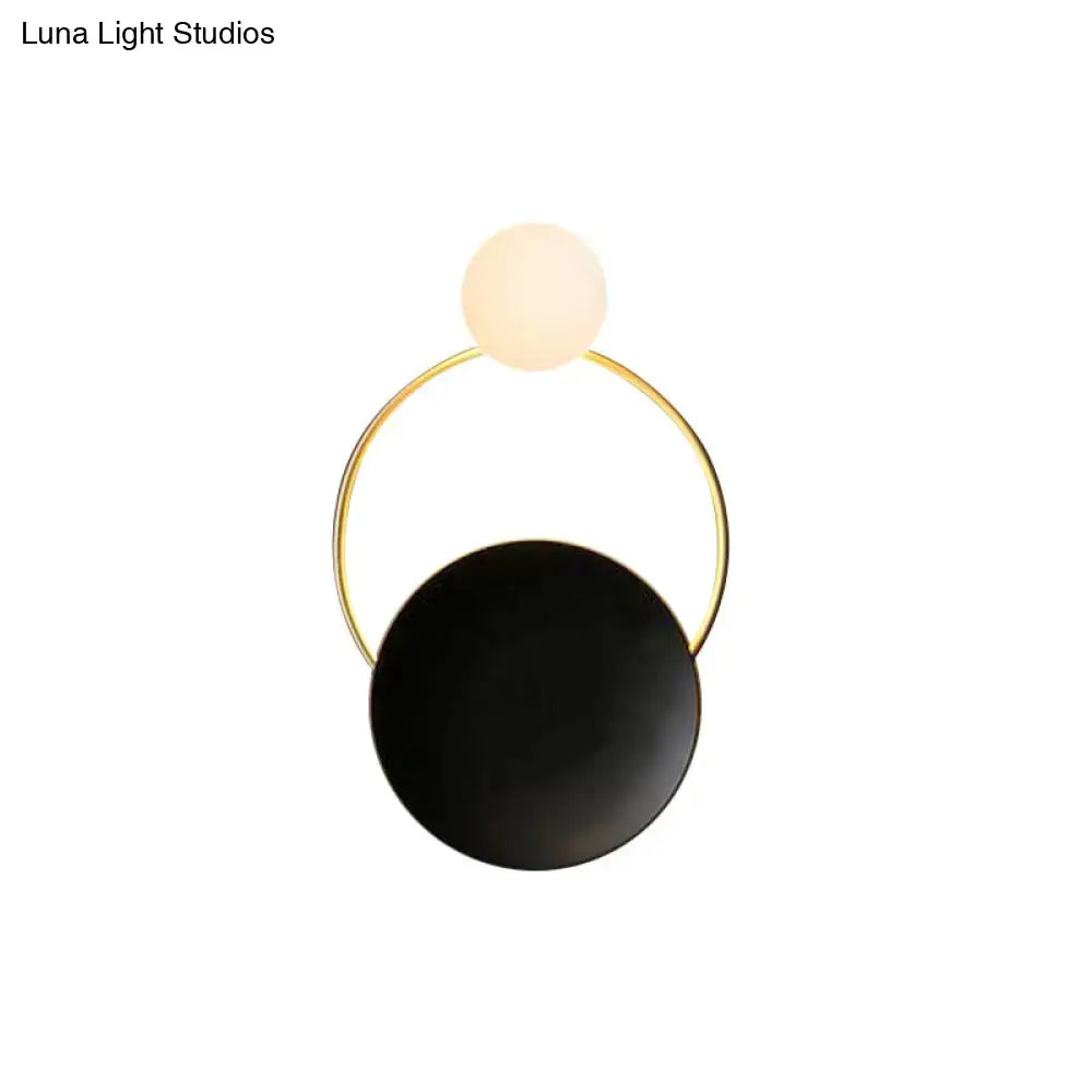 Modern circle wall sconce with sleek gold-toned frame and black and white glass globes for bedroom or corridor lighting