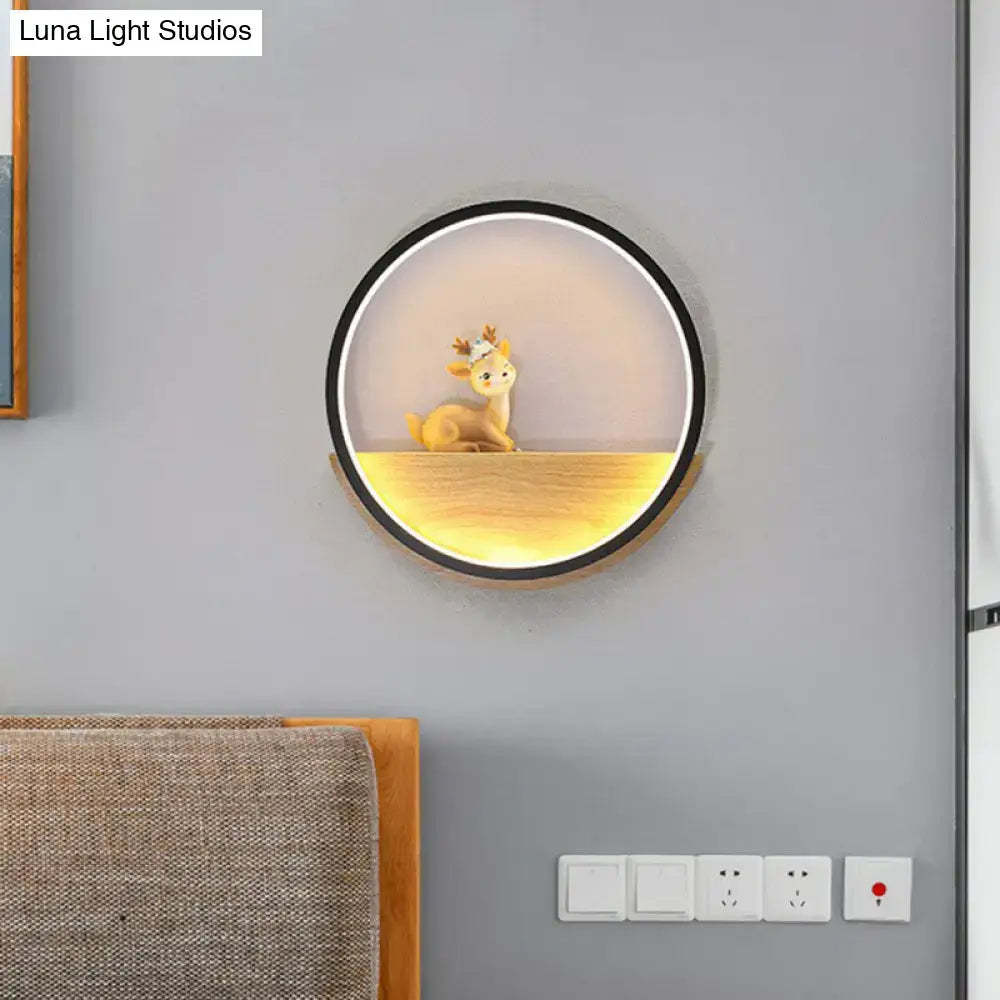 Modern circular black wall light with warm glow illuminating a decorative deer figurine on a wooden living room shelf