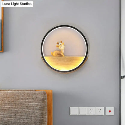 Modern circular black wall light with warm glow illuminating a decorative deer figurine on a wooden living room shelf
