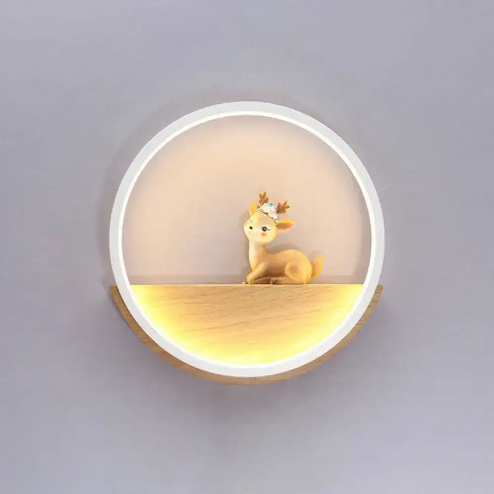 Modern circular black wall light with decorative deer figurine and floral headband on warm-lit wooden shelf