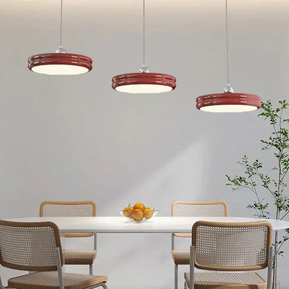 Three modern red pendant lights with sleek ribbed design complement decorbites circular modern chandelier dining room decor