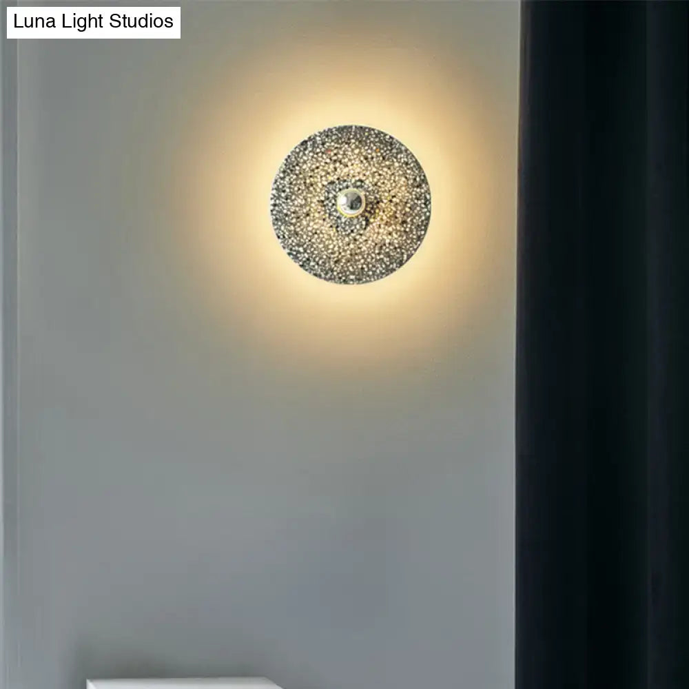 Modern circular terrazzo wall light in beige and lake blue with textured crystals and polished brass for corridors