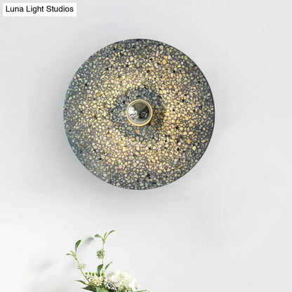 Modern circular terrazzo wall light in beige lake blue with speckled concrete and brass bulb holder for corridors
