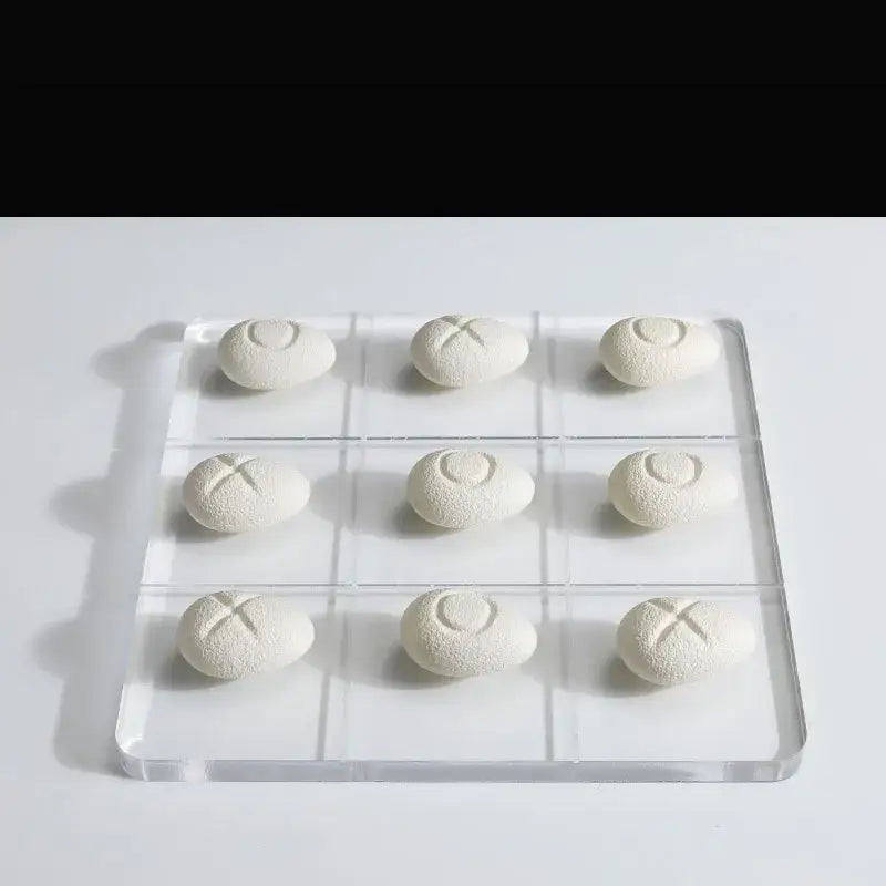 Modern clear acrylic tic tac toe board with white textured resin pebble chess pieces for elegant living room decor