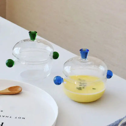 Modern clear and green glass bowl set with colorful spherical handles and lids perfect for kitchen simmer pot use