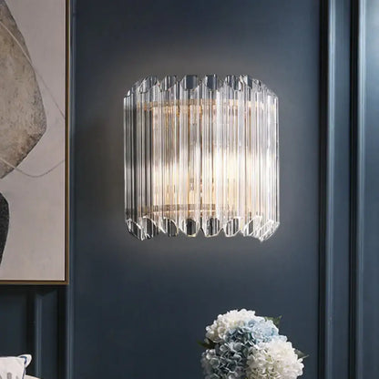 Modern clear crystal half drum light fixture with vertical prismatic rods and scalloped base bedroom wall sconce