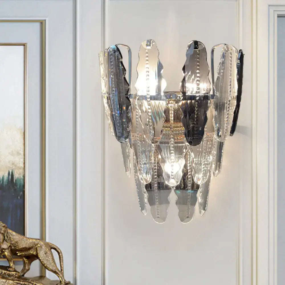Elegant modern wall sconce with clear crystal and smoked glass shards framed in sleek chrome for living room lighting