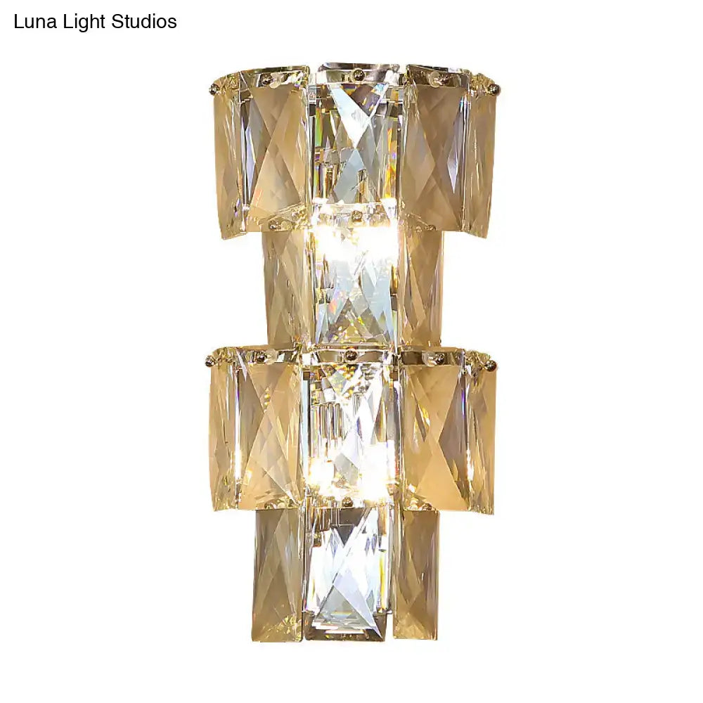 Modern wall lamp with stacked faceted gold-toned clear crystal rectangles and central illuminated light in chrome sconce kit