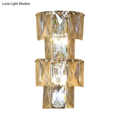 Modern wall lamp with stacked faceted gold-toned clear crystal rectangles and central illuminated light in chrome sconce kit