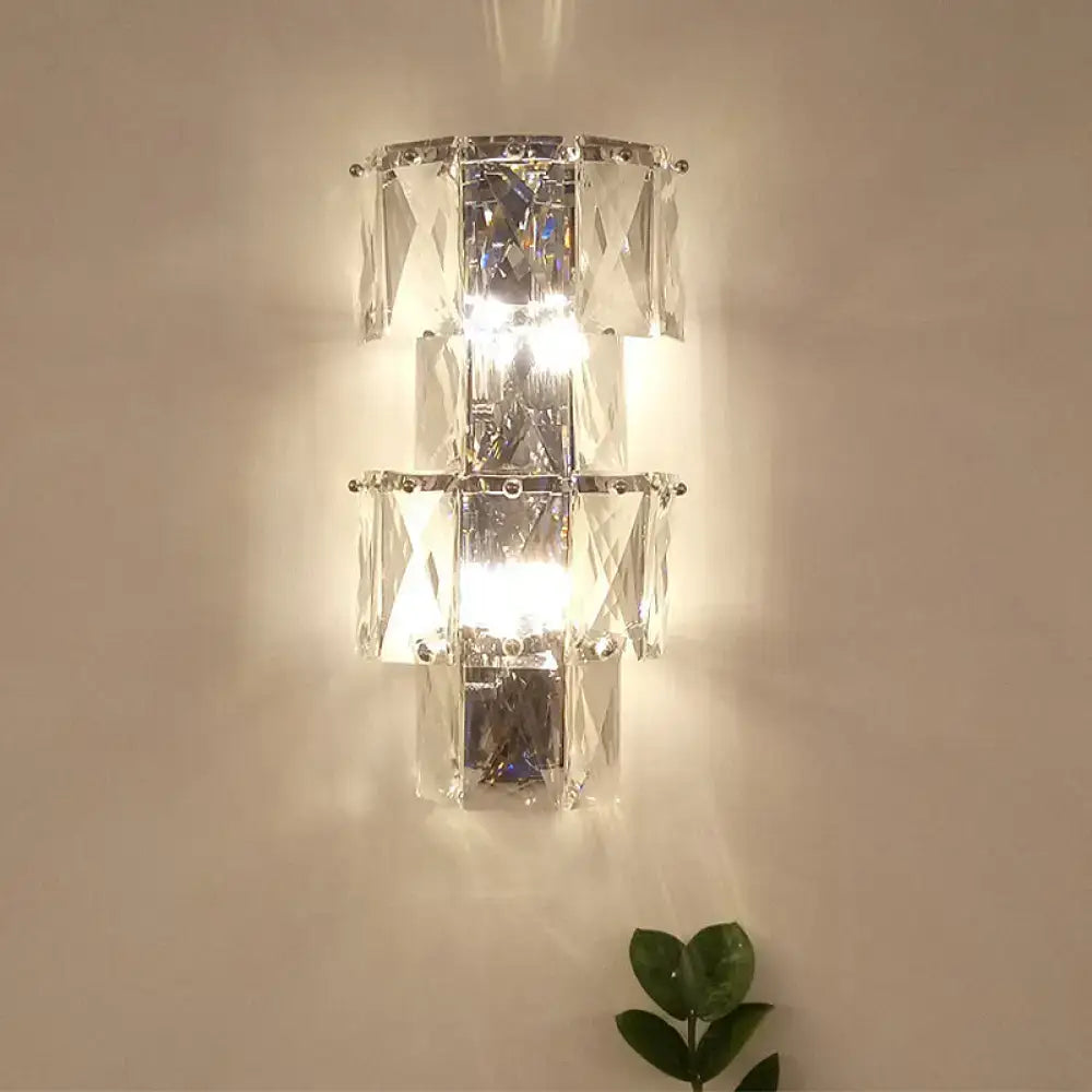 A modern clear crystal tiered wall lamp with polished chrome frame included in lamp kit for bedroom use