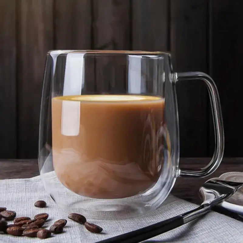 Modern clear double wall borosilicate glass mug with handle filled with brown latte for kitchen coffee use