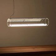 Modern clear glass cylinder pendant light with metallic mesh interior emitting warm white LED illumination for dining room