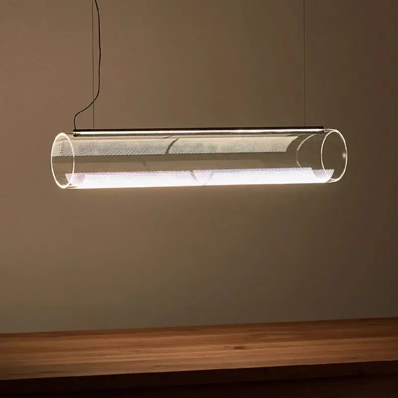 Modern clear glass cylinder pendant light with metallic mesh interior emitting warm white LED illumination for dining room