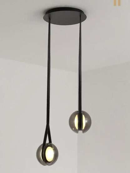 Modern clear glass designer pendant lights with sleek black spherical shades and minimalist metal chains for bedroom decorbites designer pendant lights