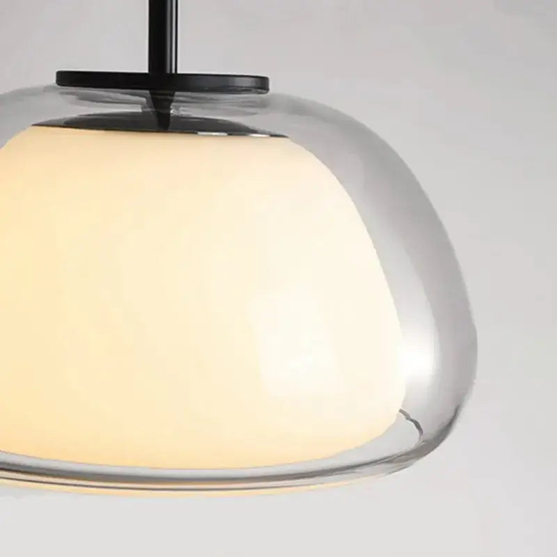 Modern clear glass jelly pendant lamp with warm glowing shade and black metal hardware for living room and dining room