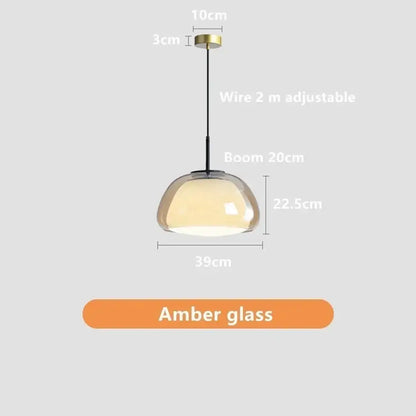 A modern jelly pendant lamp with a dome-shaped amber glass shade and brass ceiling mount for living room use