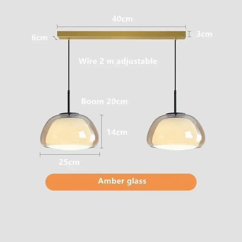 A modern jelly pendant lamp pair with amber glass domes and brass bar for living room and dining room use