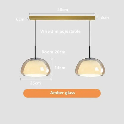 A modern jelly pendant lamp pair with amber glass domes and brass bar for living room and dining room use