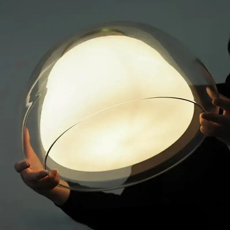 A sleek modern clear glass jelly pendant lamp with a warm diffused glow for living room and dining room