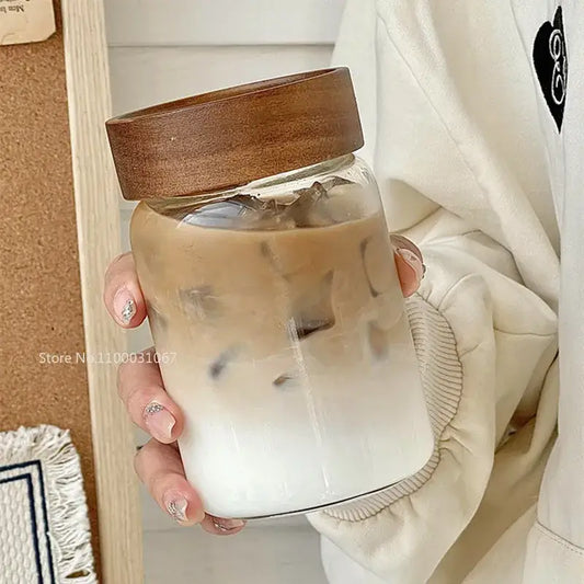Modern clear glass tea cup with warm brown wooden lid filled with iced coffee for kitchen use