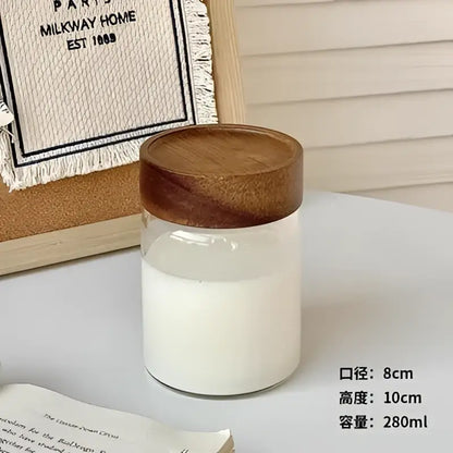 Modern clear glass tea cup with warm brown wooden lid filled with white liquid for kitchen coffee storage