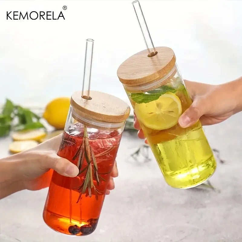 Modern clear glass tumbler cups with bamboo lids and clear straws filled with colorful infused drinks in a 4-piece set