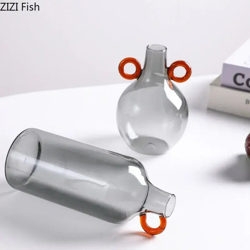 Modern clear glass vase with gray body and orange circular handles for living room decor by decorbites clear glass
