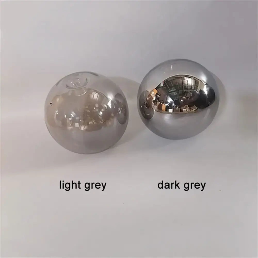 Two spherical glass shade replacements in light grey and dark grey with reflective surfaces for living room globes