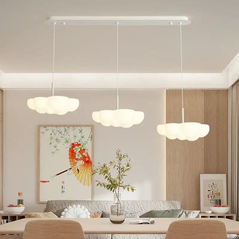 Three white cloud white floating pendant lights by decorbites hang from the ceiling in a modern dining room setting