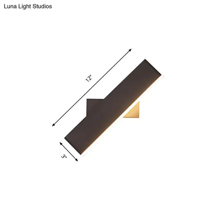 Modern coffee white rectangular sconce with a sleek black angular design and gold accent base for bedroom LED lighting