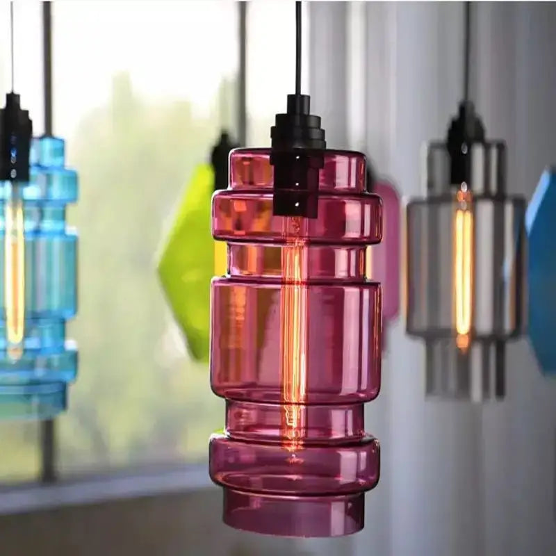 A vibrant pink tiered glass pendant light with a visible filament bulb from decorbites geometric glass pendant lights