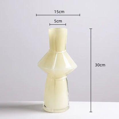 A translucent cream-colored glass vase with a flared neck and faceted design in the decorbites colorful geometric set
