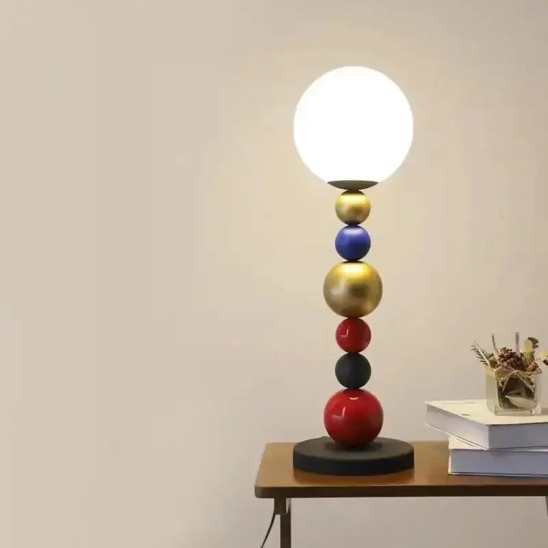 A modern floor lamp with colorful glass ball accents in gold blue red and black and a white globe shade for living room