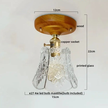 A clear glass ceiling lamp with intricate floral etchings mounted on brass copper socket and warm wood plate by decorbites colorful glass led