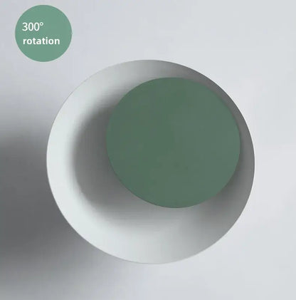 A minimalist sage green and white ceramic led wall lamp with matte finish for bedroom and living room use