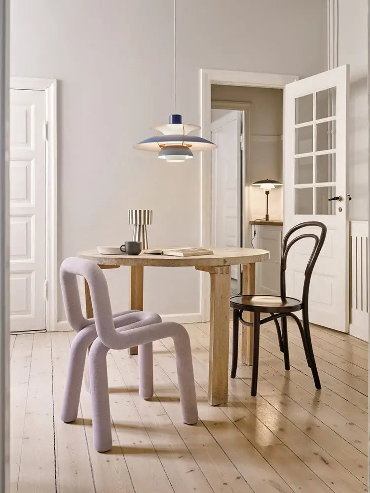 Pastel lavender upholstered chair with sculpted curved legs complementing decorbites colorful umbrella led pendant light