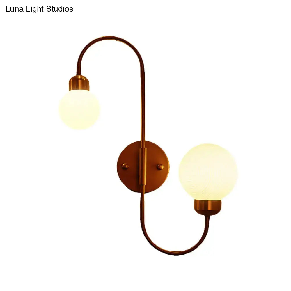 Antique brass two-light spherical wall sconce with frosted glass globes for modern white glass living room lighting