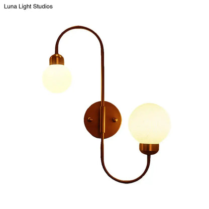 Antique brass two-light spherical wall sconce with frosted glass globes for modern white glass living room lighting
