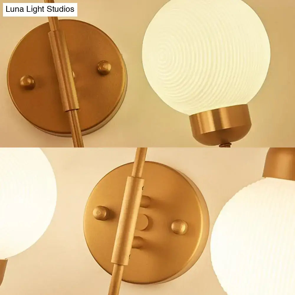 Modern copper and white glass spherical wall sconce with gold-toned frosted globe for living room lighting