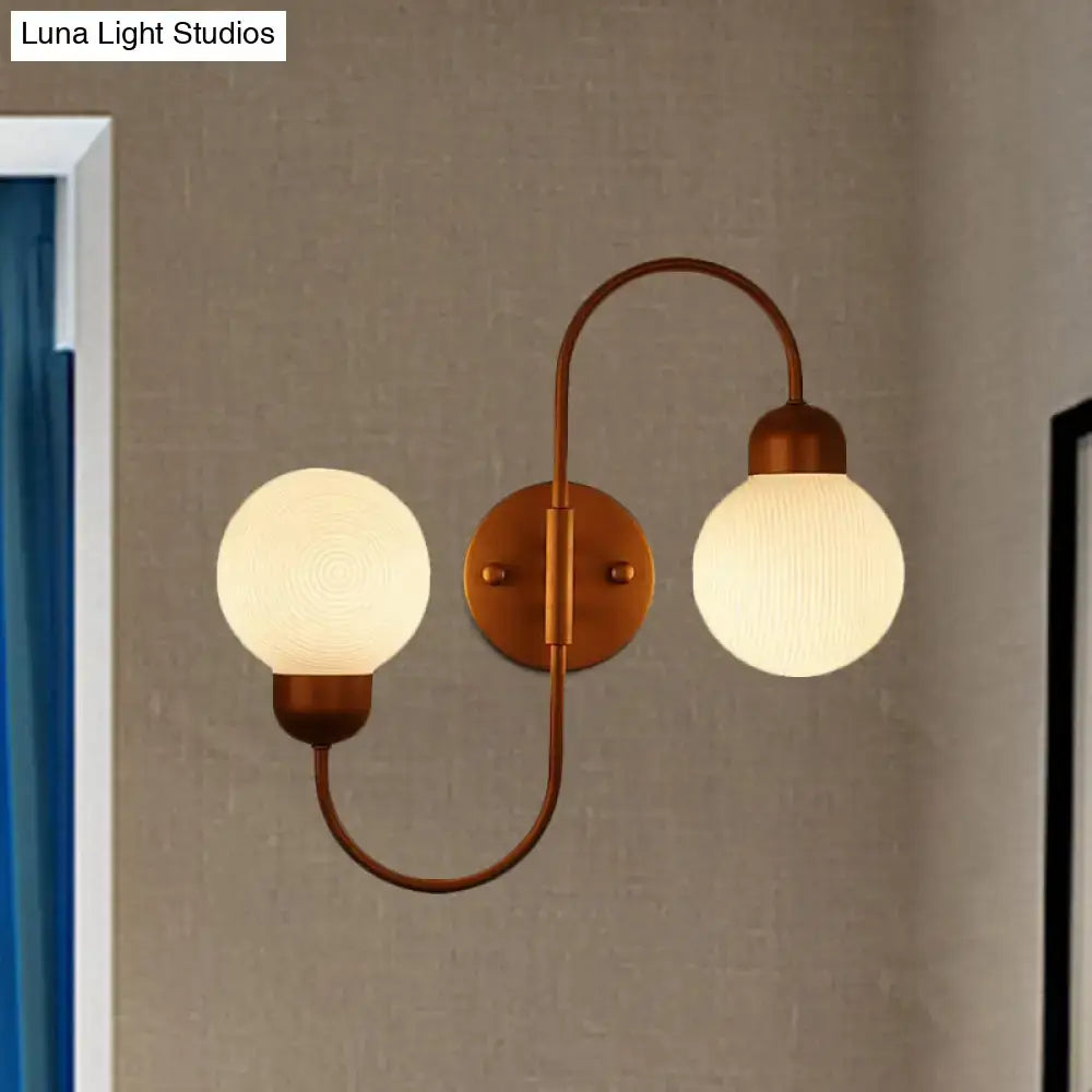Modern copper and white glass spherical wall sconce with antique brass double arms for living room lighting