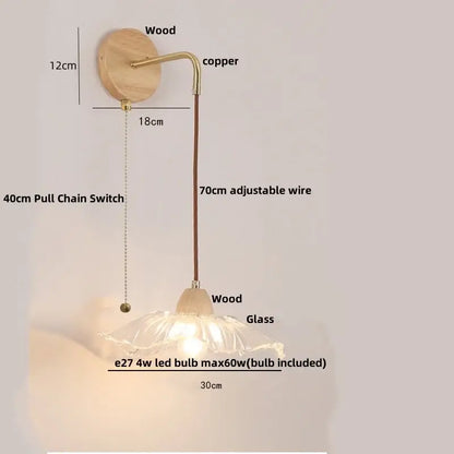 Modern copper and wood wall sconce with clear glass lampshade and pull chain switch on natural wood base