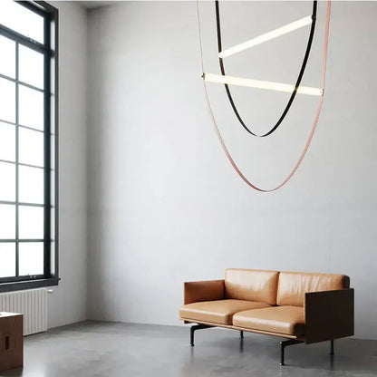 Tan leather sofa with dark wooden frame and black metal legs complementing modern decorbites leather belt chandelier