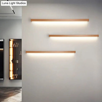 Three modern minimalist linear shaped wall sconces with warm copper finish for living room lighting