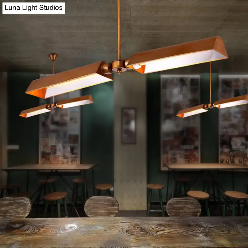 Modern copper metal triangle pendant light with warm glowing illumination for kitchen island lighting
