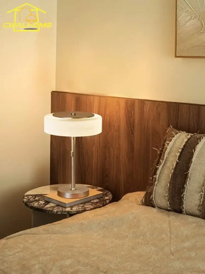 Modern cream glass table lamp with a sleek silver metal base and frosted white cylindrical shade for bedroom decorbites cream glass