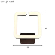 Modern cream square direct wired electric wall sconce with dark brown base providing warm white natural light
