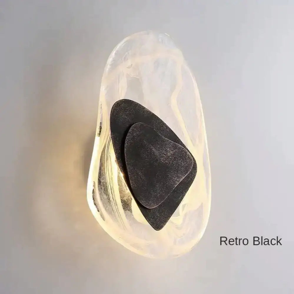 Modern creative minimalist black wall sconce with amber glass and layered metal accents for bedroom bedside lighting
