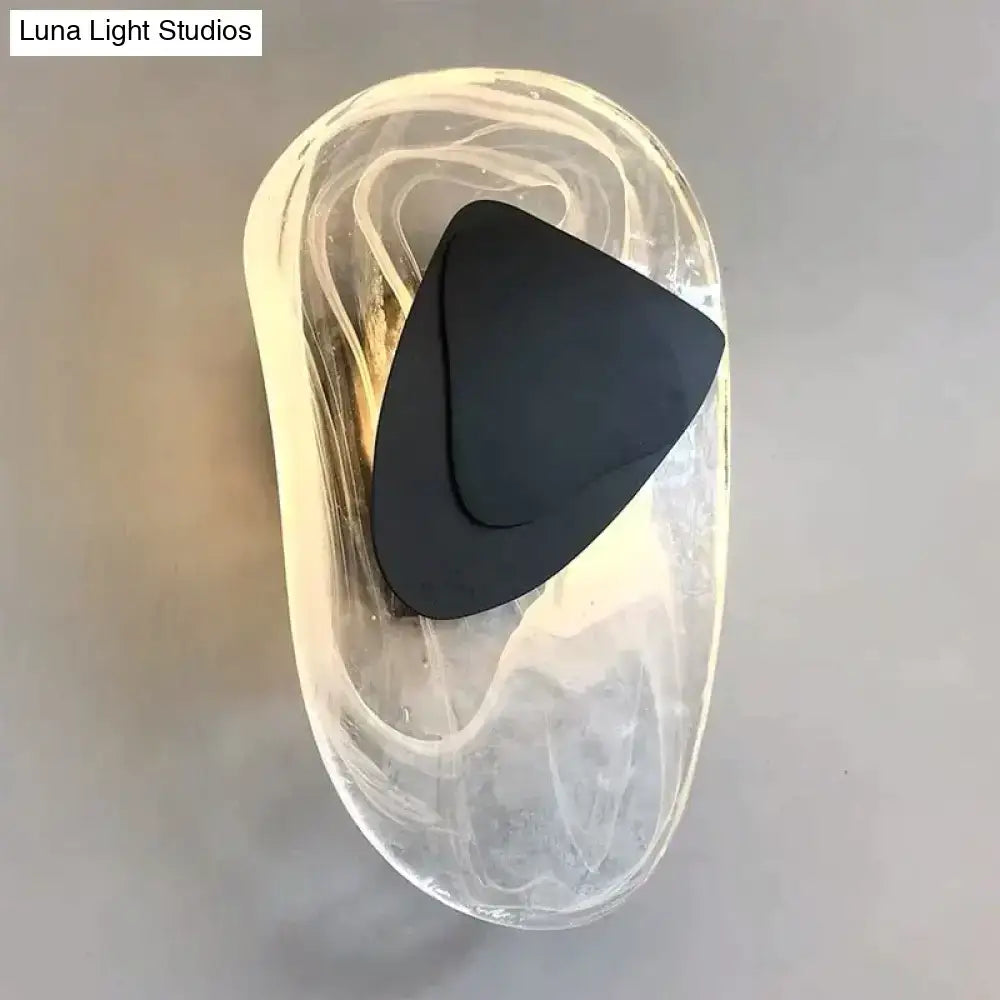 Modern creative minimalist glass wall lamp with a sleek black triangular light and marbled translucent amber housing